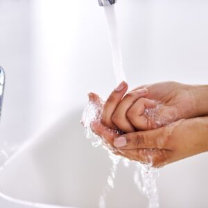 Practicing healthy hygiene habits. Cropped shot of a woman washing her hands at a sink.